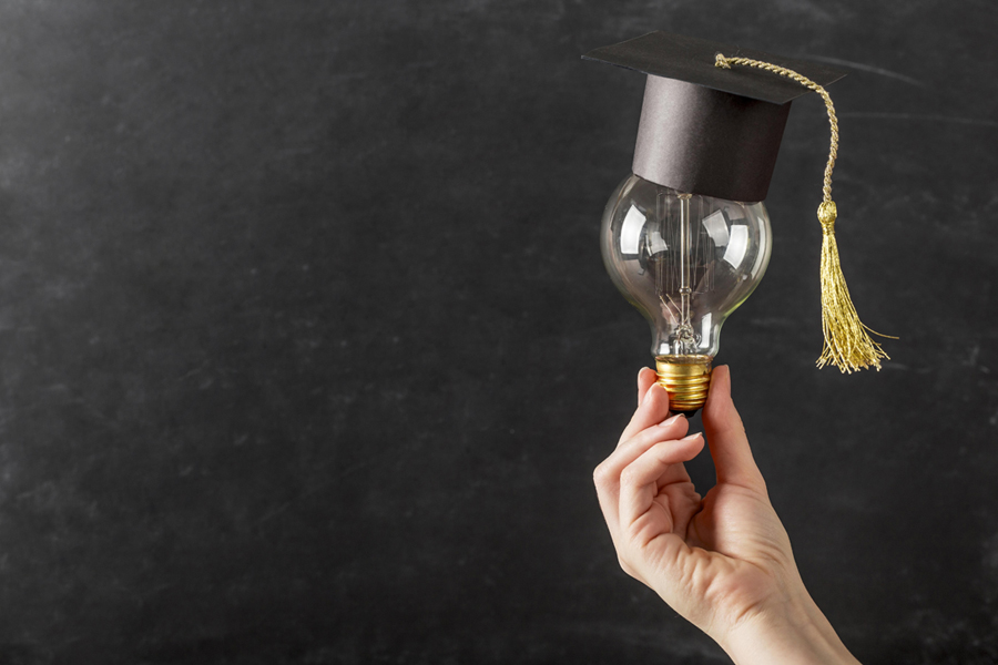 person-holding-light-bulb-with-graduation-cap